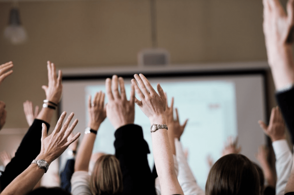 Close up of hands raised up in classroom