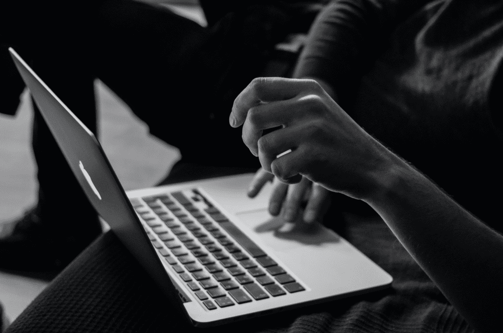 Hands typing on a laptop