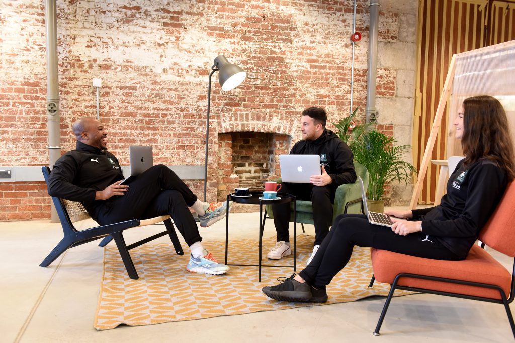 Group of three people sat working in a shared co-working space